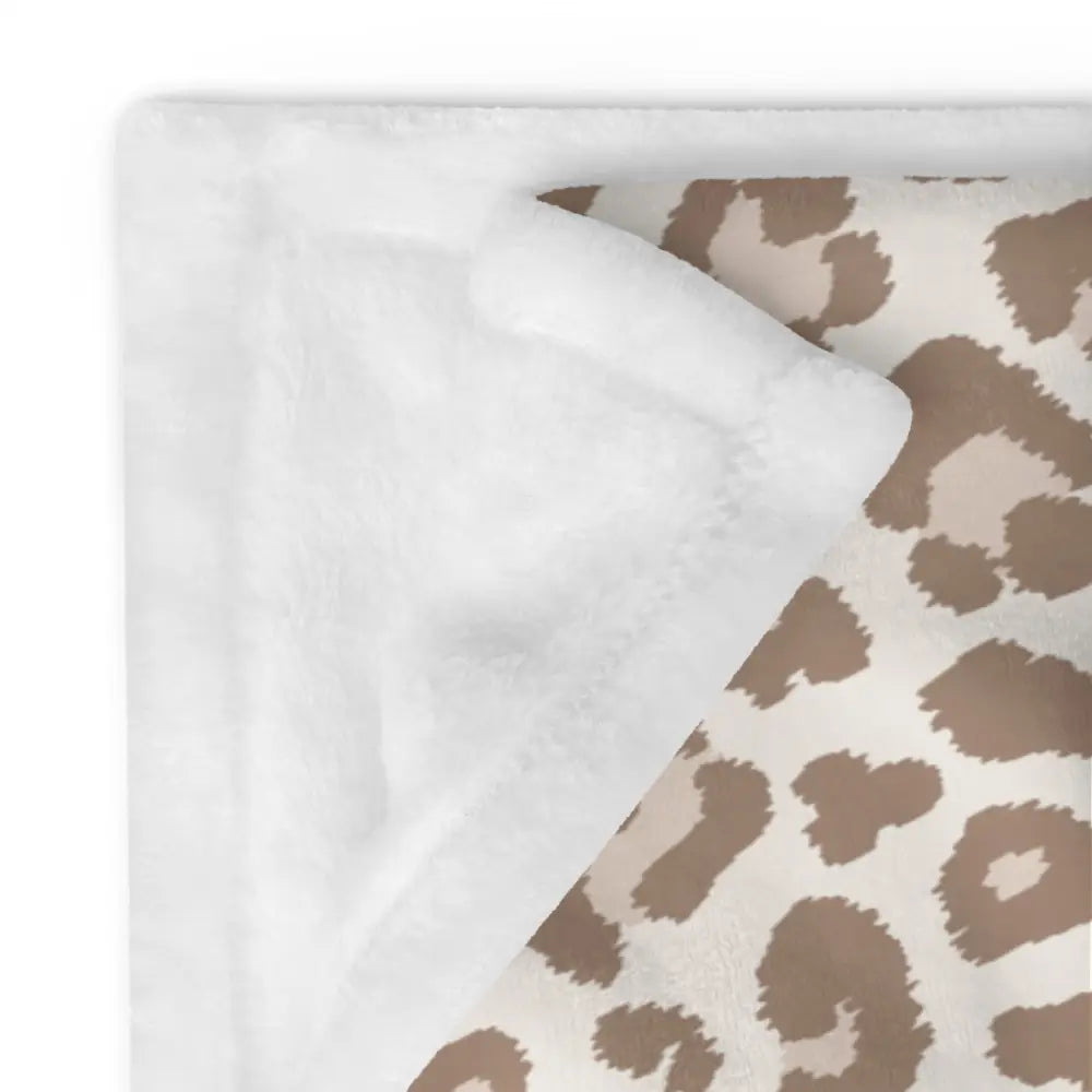Tan leopard print blanket with plush beige and brown leopard pattern on one side and soft white fleece lining