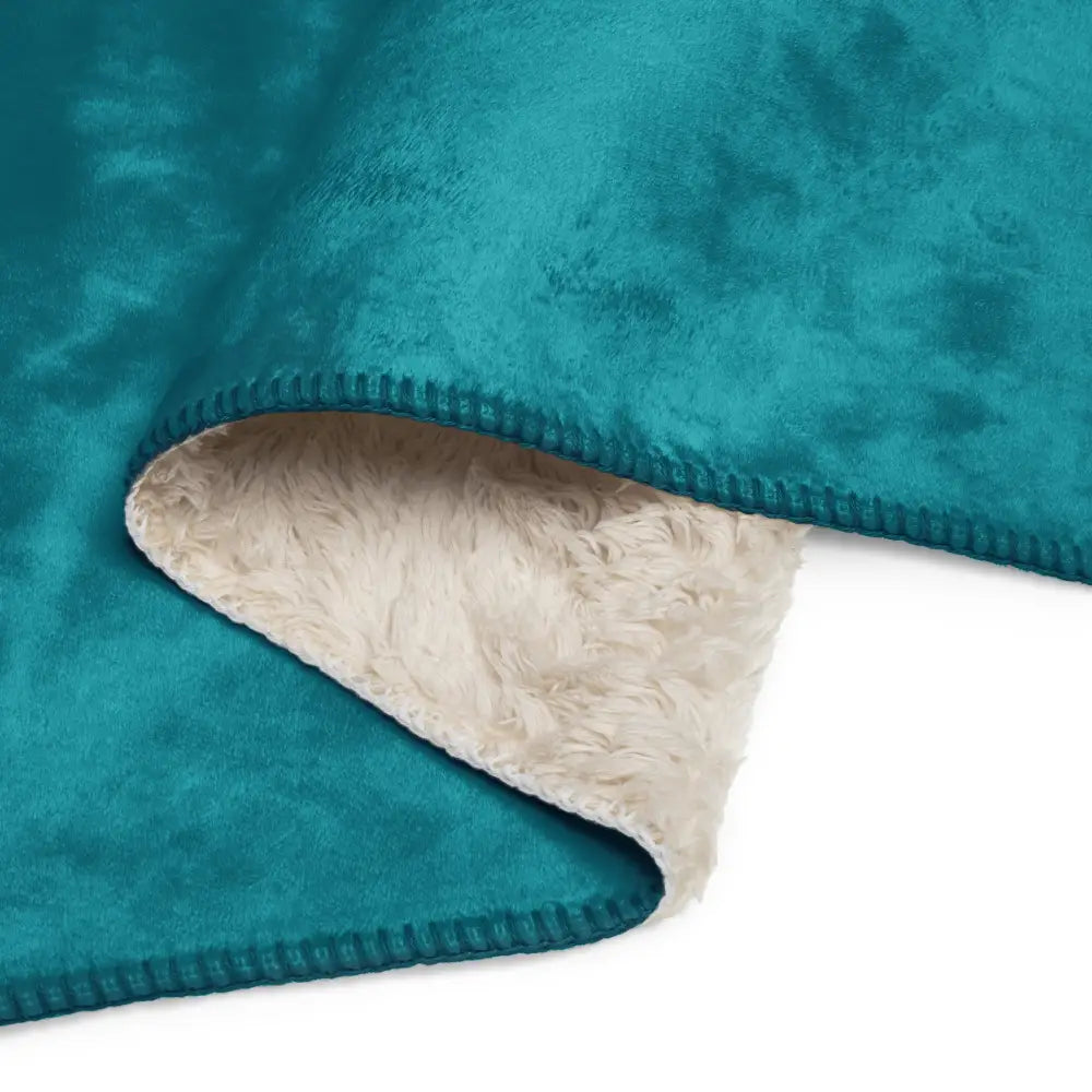 Teal sherpa throw blanket with soft fluffy cream-colored interior lining for warmth and comfort