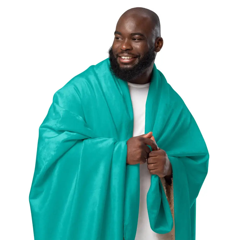 A vibrant teal satin shawl draped over a man’s shoulders showcasing the turquoise sherpa blanket material
