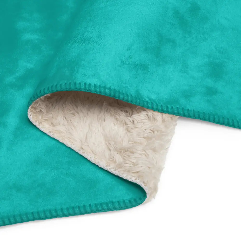 Turquoise sherpa blanket with a teal plush exterior and soft fluffy cream-colored interior lining for cozy warmth