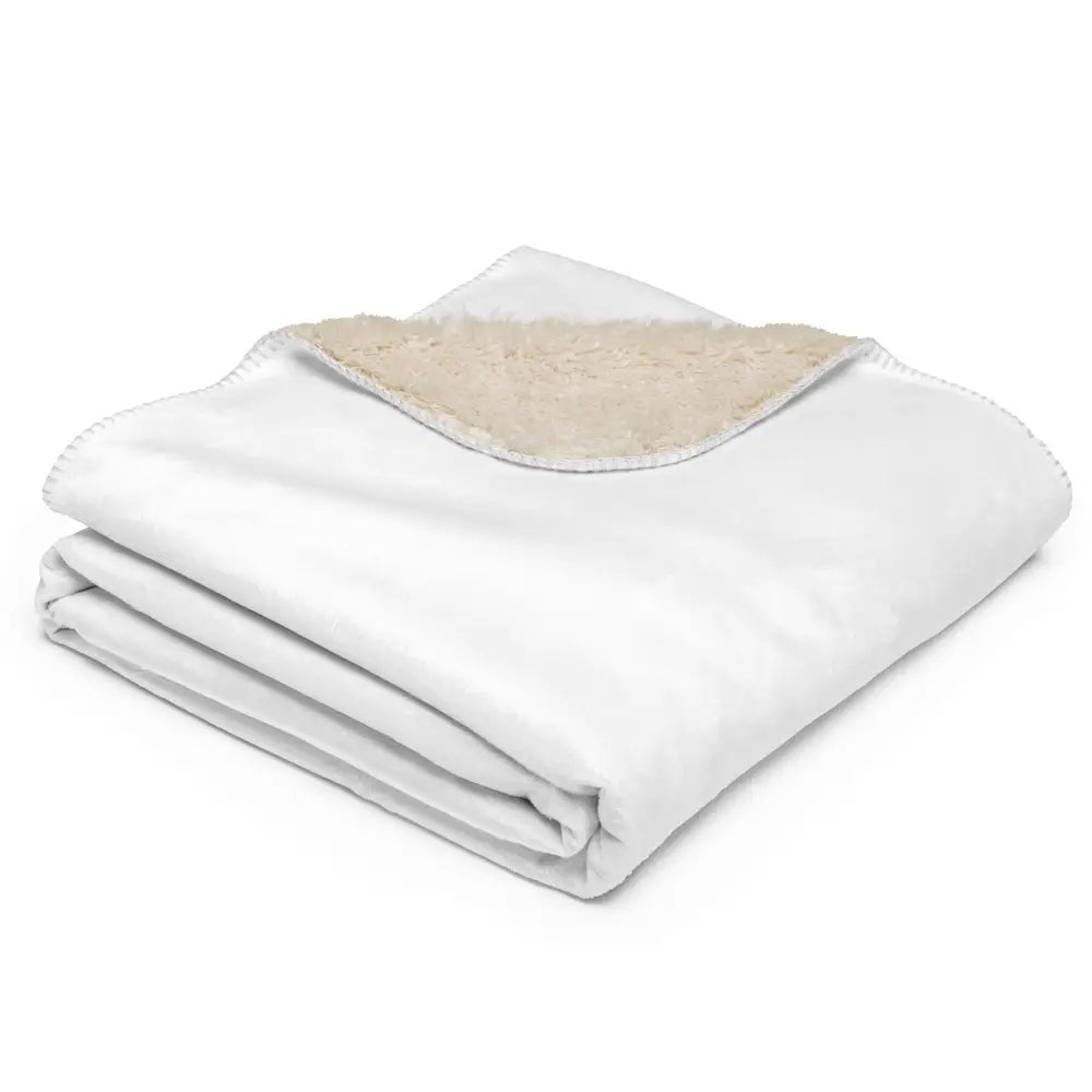White sherpa blanket featuring a white fleece exterior with a soft cream-colored sherpa lining for warmth
