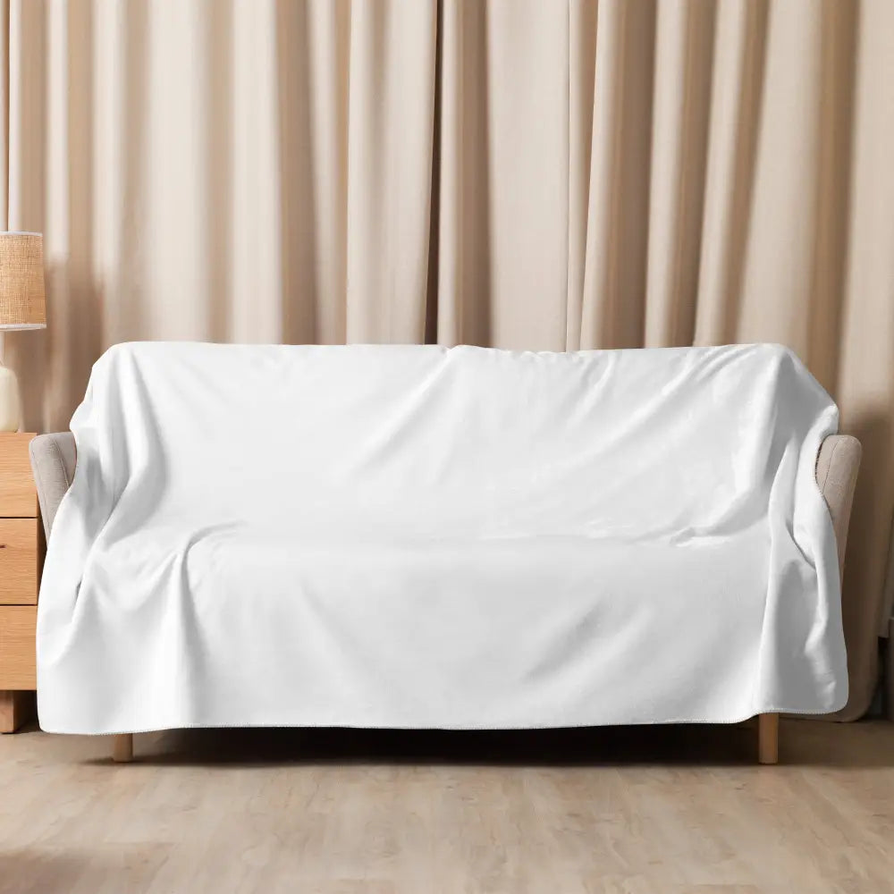 White sherpa blanket draped over a light-colored couch as a white fabric sofa cover showcasing soft material and cozy use